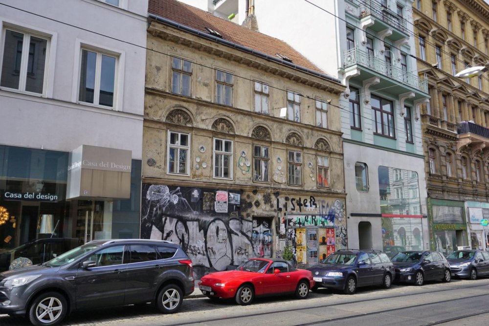 Biedermeierhaus Breite Gasse 15 in Wien mit Graffiti, Autos, Schienen, Neubau (7. Bezirk)