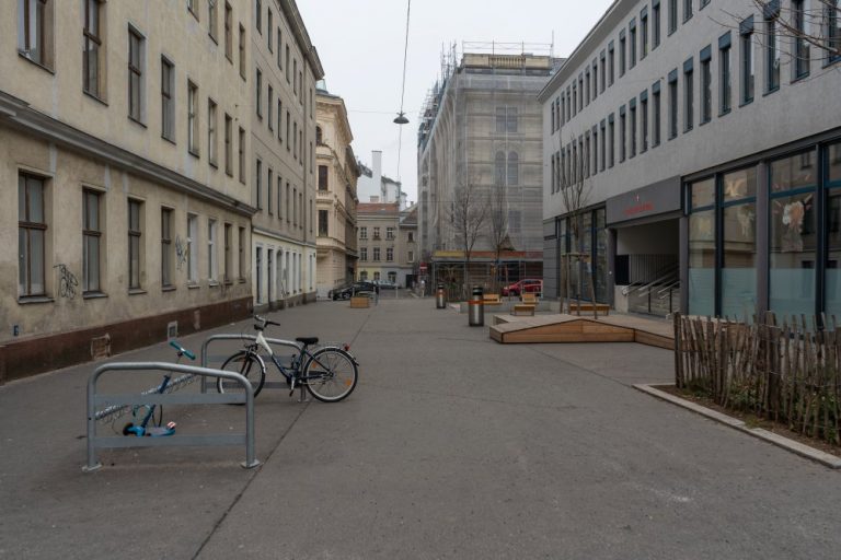 Autofreier Schulvorplatz in der Gasgasse, Asphaltfläche, Bäume, 1150 Wien