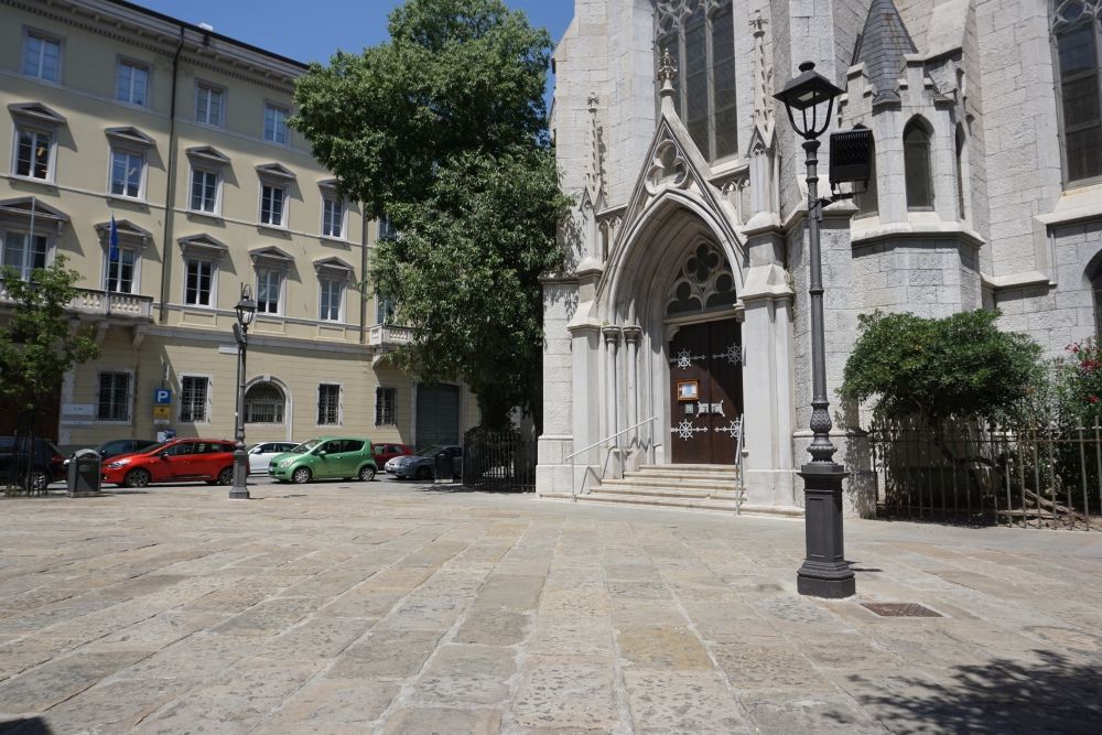 Platz mit Kirche, alten Straßenlaternen und Pflasterung in Triest, Italien