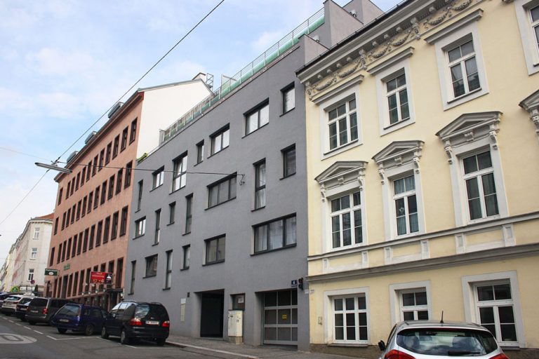 Wohnhaus in Ottakring mit grauer Fassade, in Schutzzone, erbaut nach Abriss eines Gründerzeithauses, nahe Thaliastraße