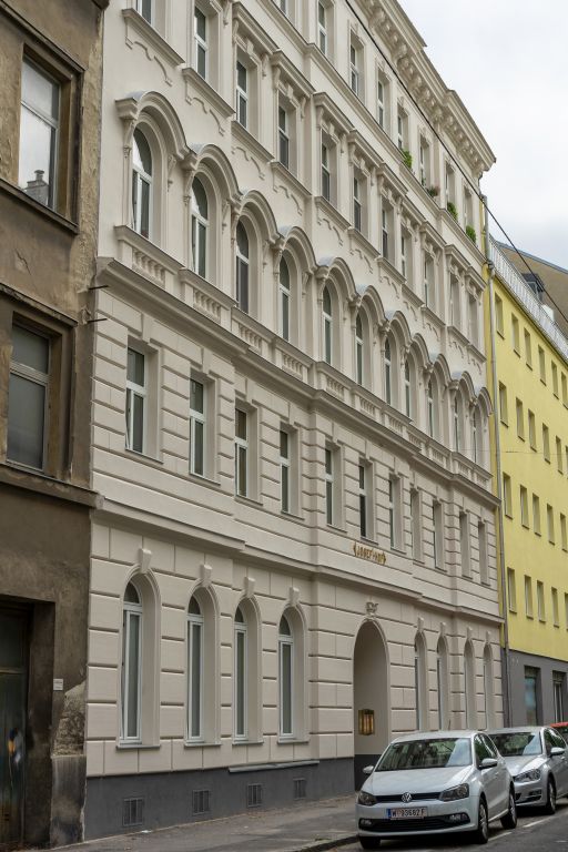 Gründerzeithaus mit renovierter und rekonstruierter Fassade in Wien-Landstraße, Häuserzeile, Autos