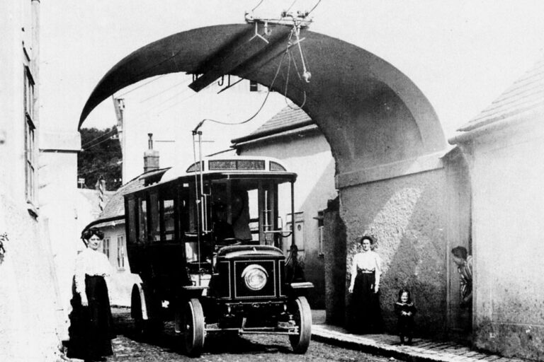 historische Aufnahme von Kalksburg, Oberleitungsbus fährt durch den Torbogen beim Mackschlössl, Liesing, Wien