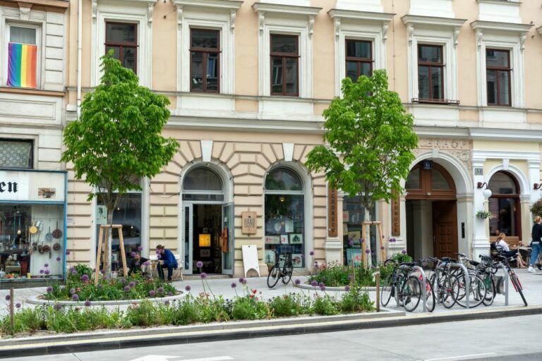 Burggasse nach der Umgestaltung, breiter Gehsteig, Bäume, Pflastersteine, Räder