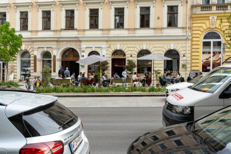 Burggasse nach der Umgestaltung, breiter Gehsteig, Bäume, Pflastersteine, Räder, Autos