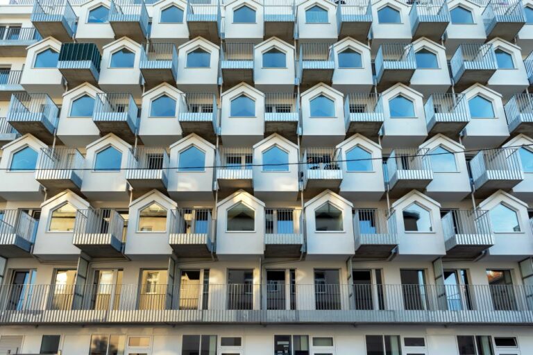 Fassade eines Hauses in Wien-Simmering, Gudrunstraße 1, Balkone, Metallgitter, Erker