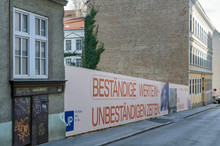 Baulücke zwischen zwei Altbauten, Plakat "Beständige Werte in unbeständigen Zeiten"
