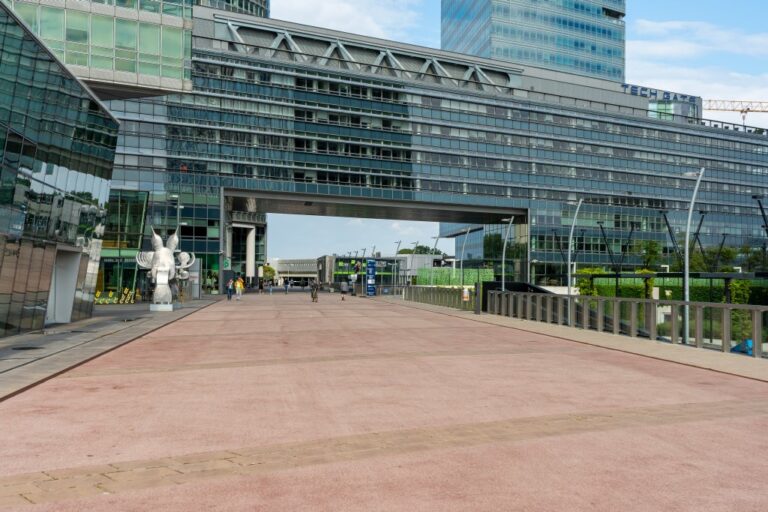 langes Bürohaus oberhalb einer Fußgängerfläche, Glasfassade, Hochhaus