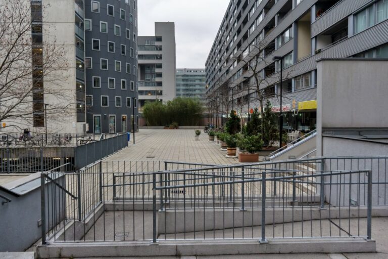 Wohnhäuser in einem modernen Stadtteil in Wien, Fußgängerzone, Geländer, Bäume, Sträucher