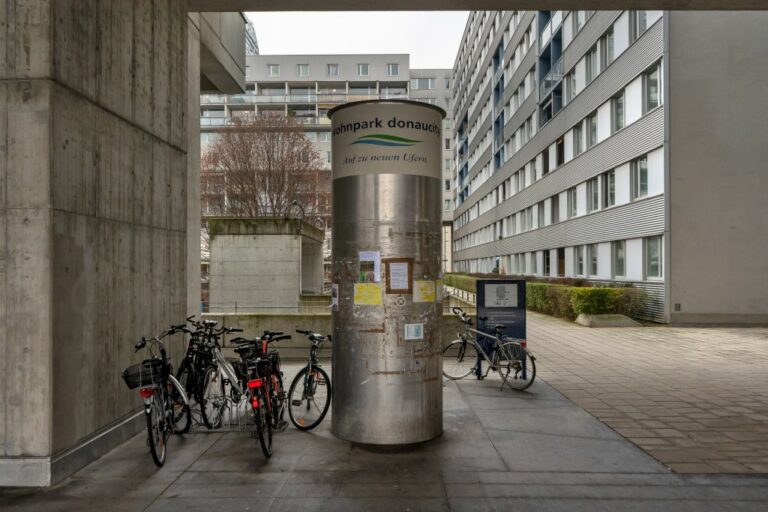 Litfaßsäule beim Wohnpark Donaucity, Fahrräder, Wohnhäuser