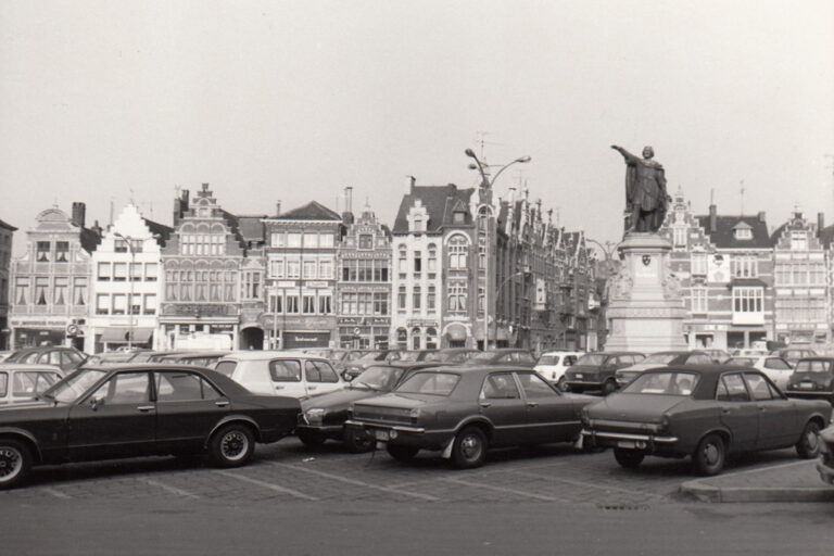 alter Platz mit parkenden Autos und Statue eines Mannes in Flandern/Belgien