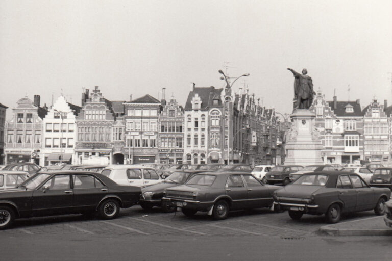 alter Platz mit parkenden Autos und Statue eines Mannes in Flandern/Belgien