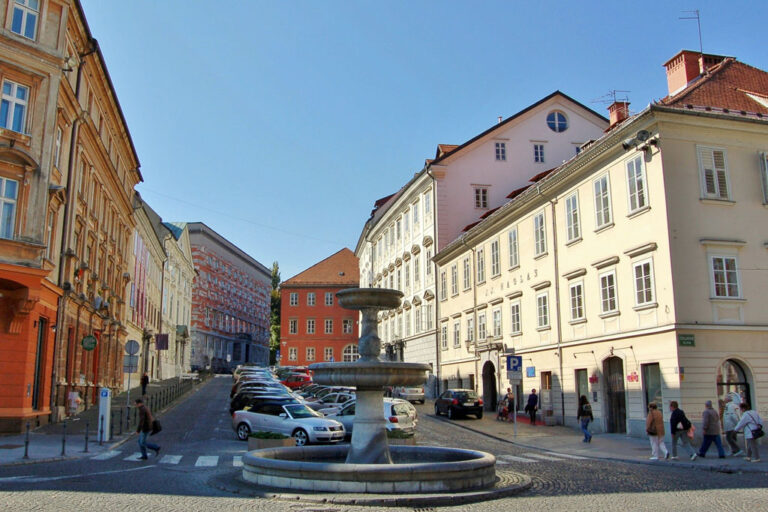 Platz, parkende Autos, Brunnen