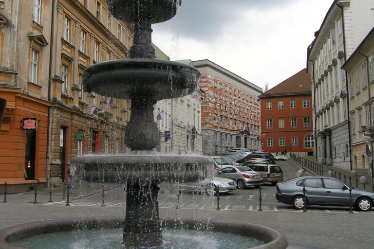 Platz in Ljubljana, parkende Autos, Brunnen