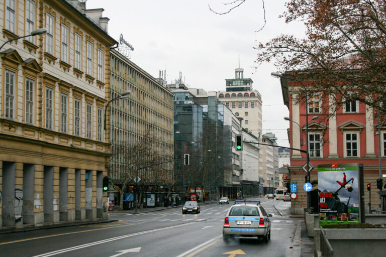 Foto einer Straße in Ljubljana mit Autos und Hochhaus im Hintergrund