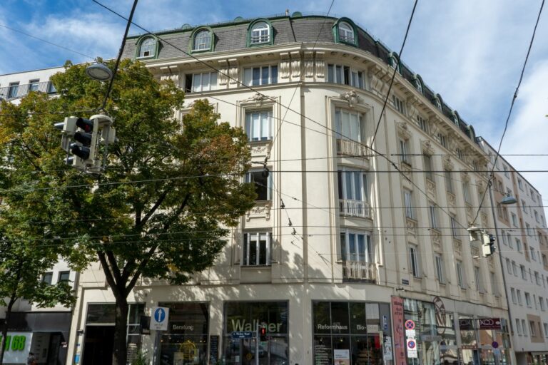 Aufnahme eines Wohnhauses im 4. Bezirk in Wien, spätgründerzeitliche Fassade, Dekor, Geschäfte im Erdgeschoß