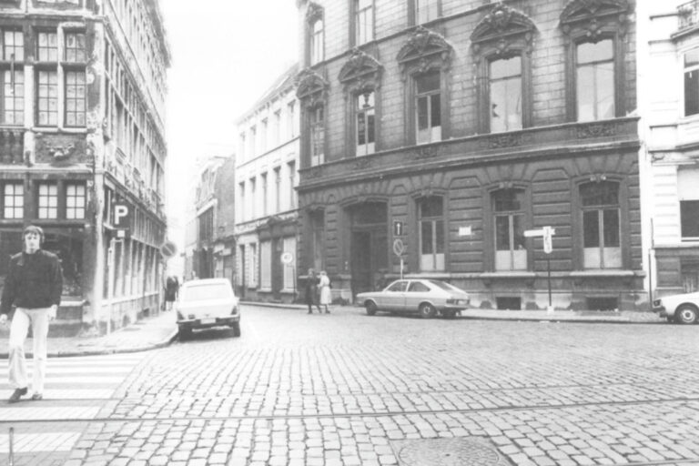 altes Foto von Gent, Autos parken vor Häusern, Mann geht über einen Zebrastreifen, gepflasterte Straße, Schienen