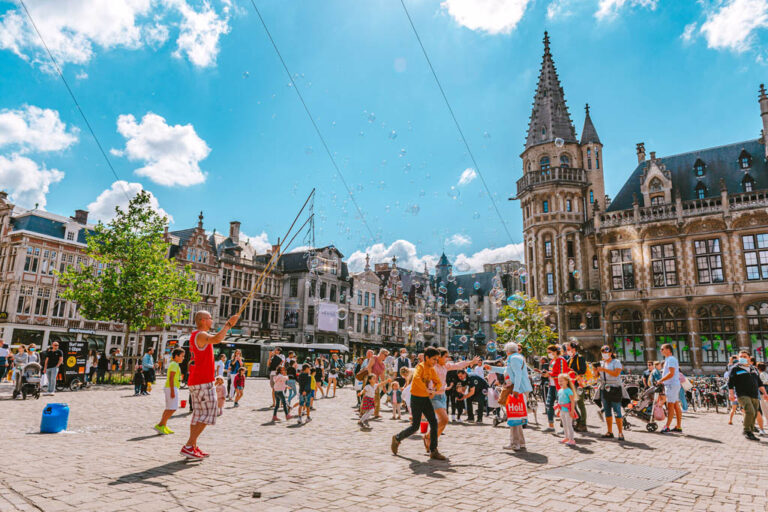 viele Menschen in einer Fußgängerzone in Gent, rechts das historische Postgebäude (Oud Postkantoor)