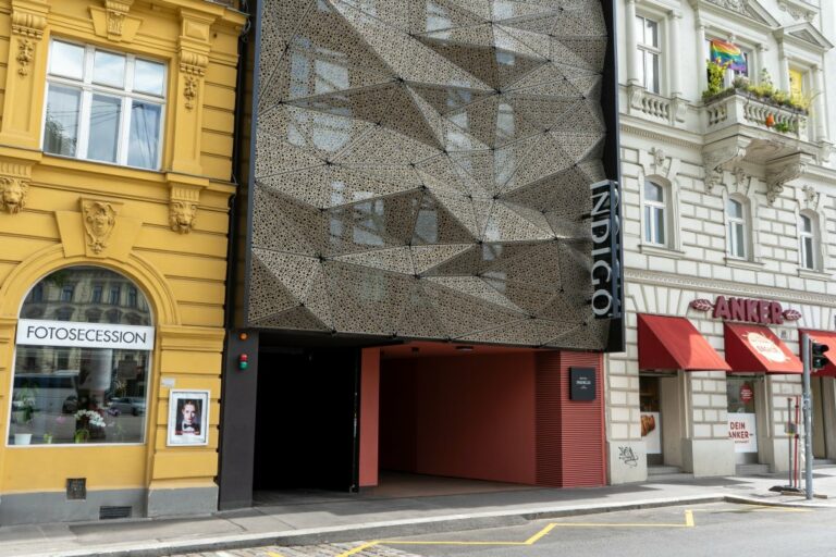 Garageneinfahrt des Hotel Indigo in Wien-Margareten, links und rechts historische Gebäude, in der Mitte eine Verkleidung mit dunklem Blech