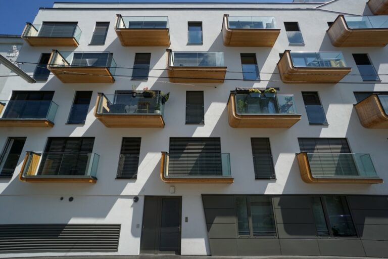 Neubau-Wohnhaus in Wien-Meidling mit Holzbalkonen und hohen schmalen Fenstern