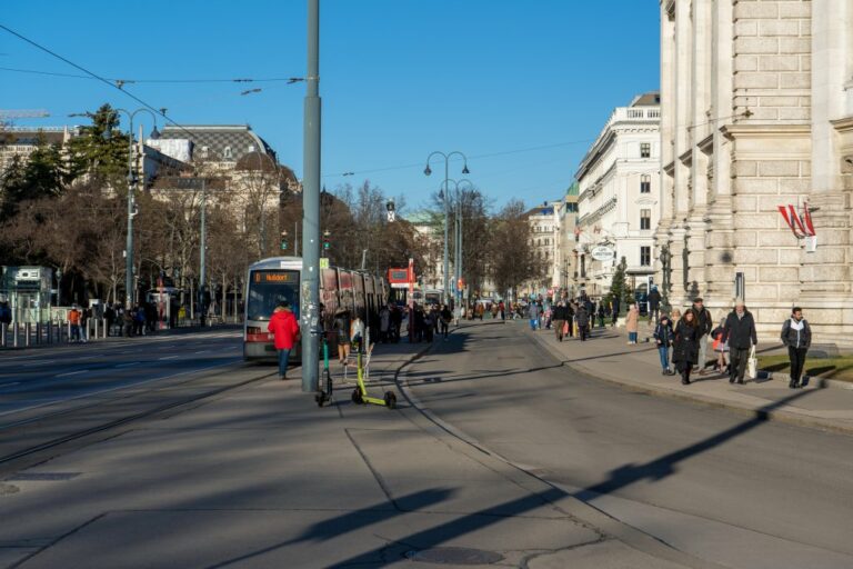 Leute vor dem Eingang des Burgtheaters, historische Gebäude, Oberleitungen, Straßenbahn, Bäume, Straßenlaternen