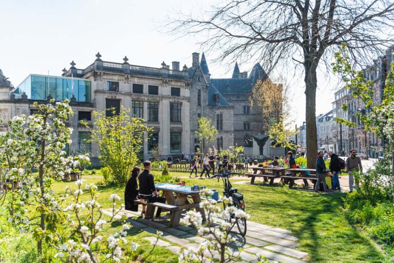 junge Leute auf einem kleinen Park im Zentrum von Gent, Bänke, Rasen, Sträucher, Baum, historische Gebäude, Haus mit Steinfassade