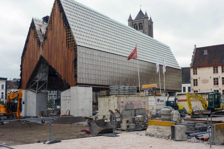 modernes Gebäude in Gent wird gebaut, Bagger, Baustelle, Kirchturm im Hintergrund