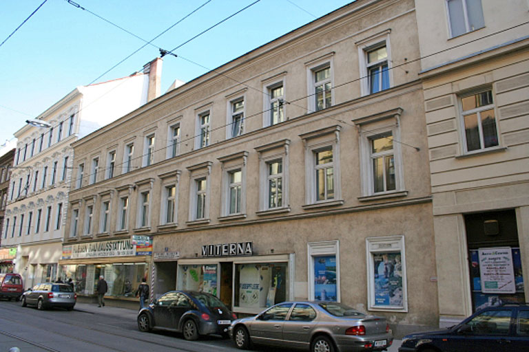 altes Haus in Wien-Neubau, Geschäfte im Erdgeschoß, davor Parkplätze