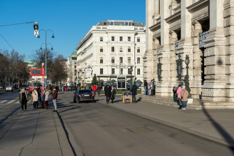 Taxi und Leute vor dem Eingang des Burgtheaters, historische Gebäude, Oberleitungen, Straßenbahn, Bäume, Straßenlaternen