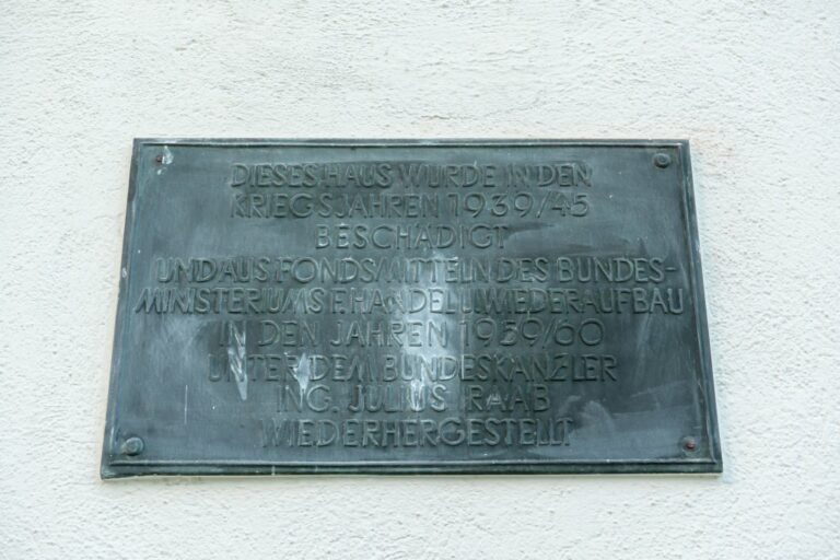 "Dieses Haus wurde in den Kriegsjahren 1939/45 beschädigt und aus Fondsmitteln des Bundesministeriums f. Handel u. Wiederaufbau in den Jahren 1959/60 unter dem Bundeskanzler Ing. Julius Raab wiederhergestellt"