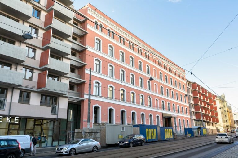 Fassade eines alten Fabriksgebäude neben Neubauten in Wien-Simmering