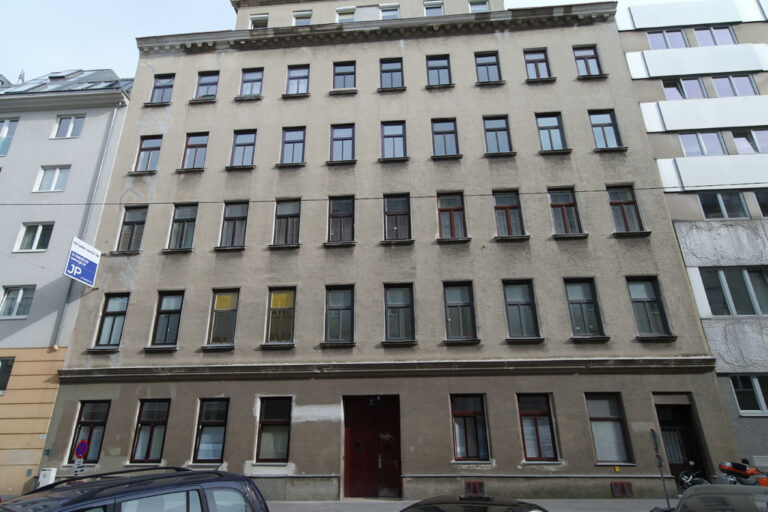 Gründerzeithaus mit glatter grauer Fassade in 1030 Wien, Schild "JP"