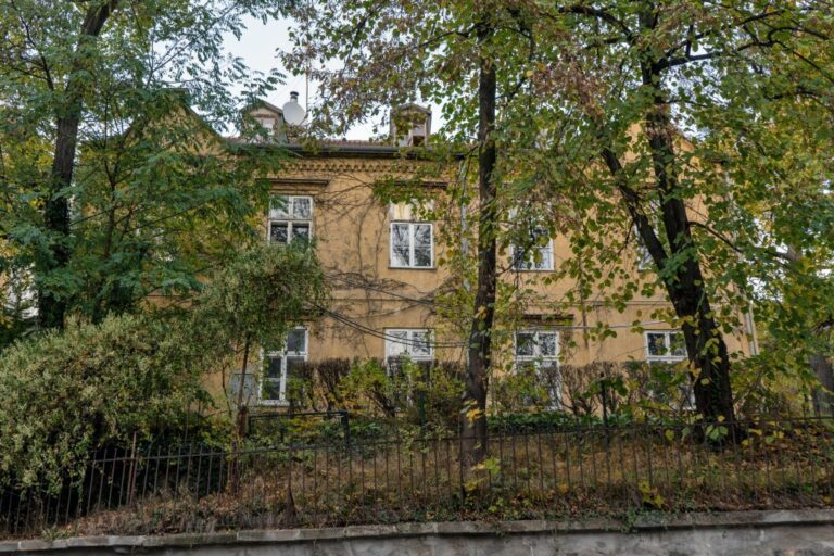 Villa in Pötzleinsdorf in Wien-Währing, historisches Gebäude hinter Bäumen und Sträuchern