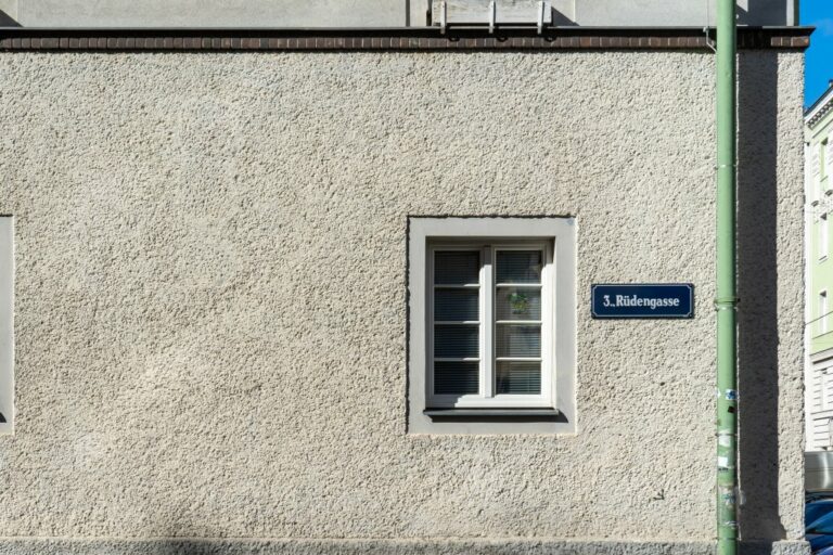 Fenster, Straßenschild und Dachrinne im Erdgeschoß des Anton-Kohl-Hofs in der Rüdengasse