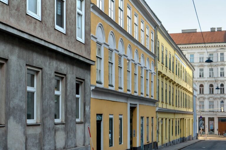 Häuserzeile aus drei alten Häusern in einer Seitengasse der Mariahilfer Straße