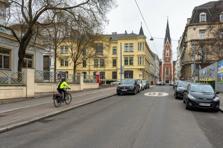 Radfahrer fährt neben dem Theater Akzent, Theresianumgasse, Pfarrkirche St. Elisabeth