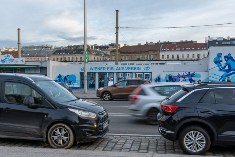 fahrende und parkende Autos vor dem Wiener Eislauf-Verein, dahinter alte Gebäude