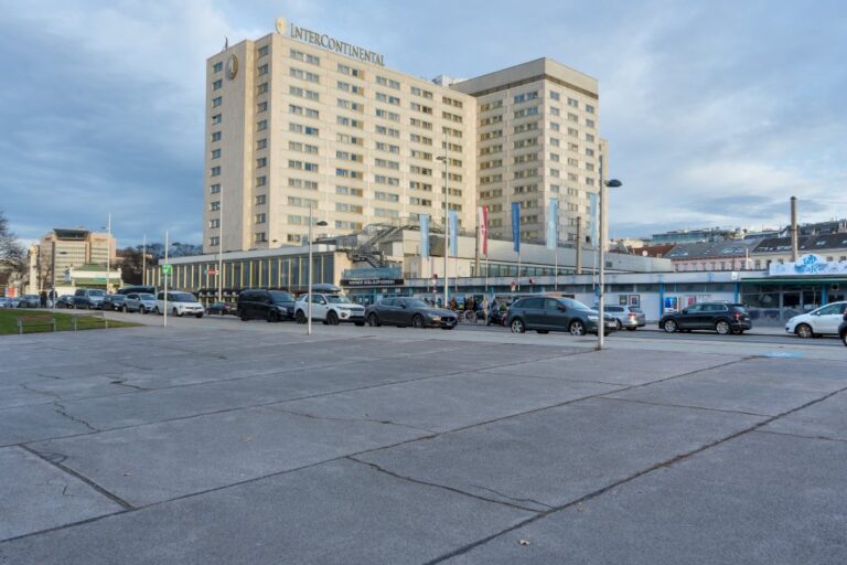 Hotelhochhaus aus der Nachkriegszeit, parkende Autos, Asphalt, Straßenlaternen