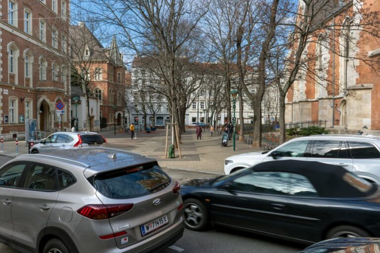 Platz in 1040 Wien, Schule, Kirche, Bäume, Autos