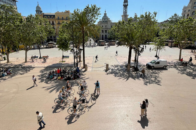 Fußgänger und Radfahrer in der Fußgängerzone vor dem Rathaus von Valencia
