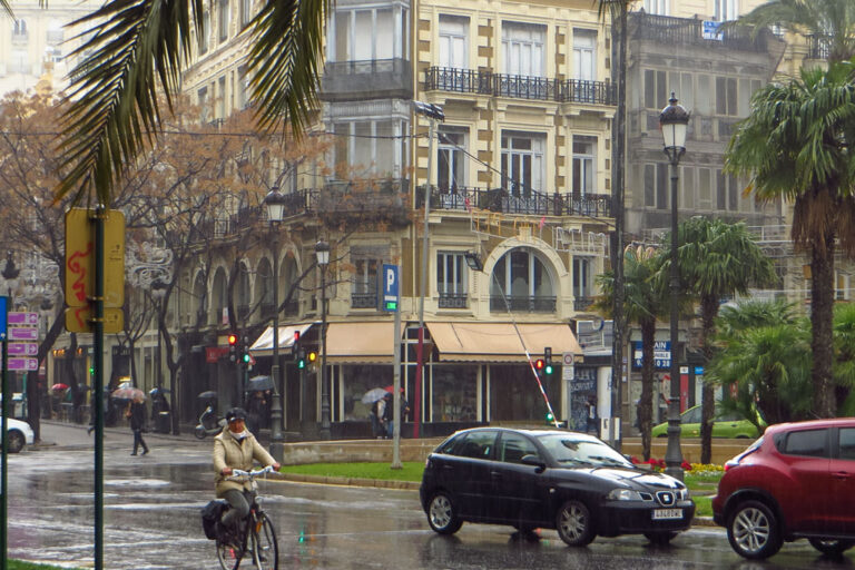 Autos und Radfahrerin fahren über einen Platz in der Altstadt von Valencia