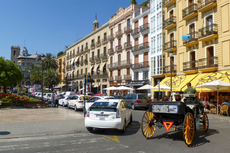 Autos und Pferdefuhrwerk auf einem Platz in Spanien