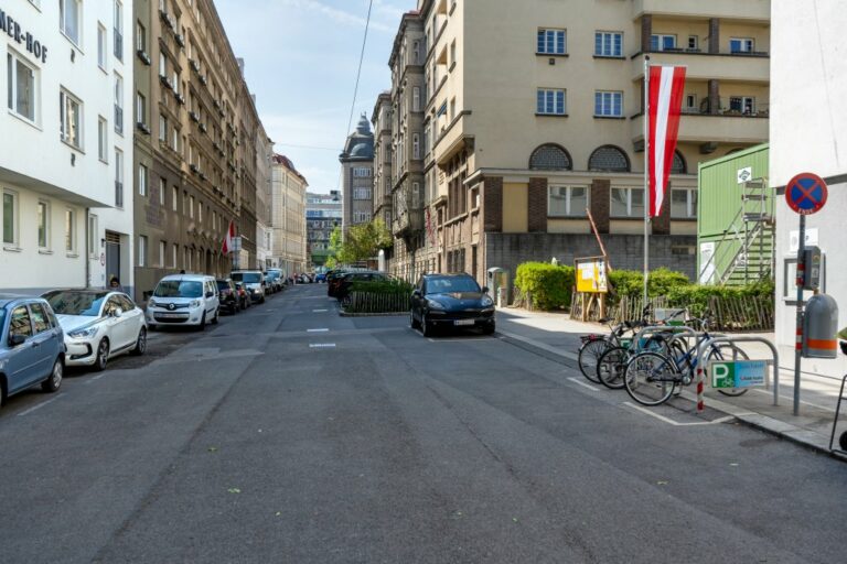 Asphalt, parkende Autos, abgestellte Fahrräder, Faberhof, Volksschule, Mittelschule