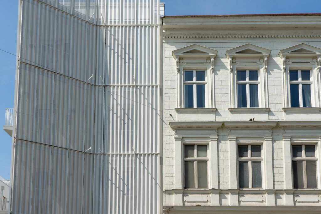 Neubau mit Blechfassade neben dekoriertem Gründerzeithaus