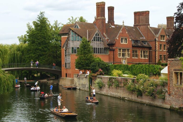 Universitätsgebäude an einem Fluss in Cambridge, Boote, Pflanzen, Leute