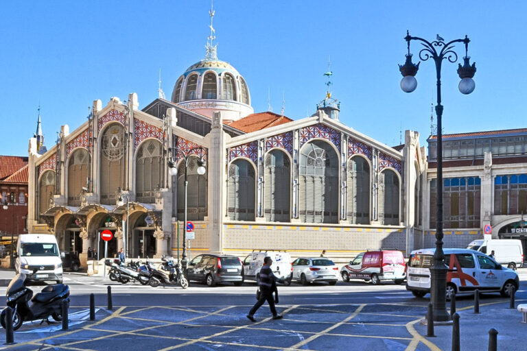 Markthalle in Valencia, Person geht über die Straße, parkende Autos