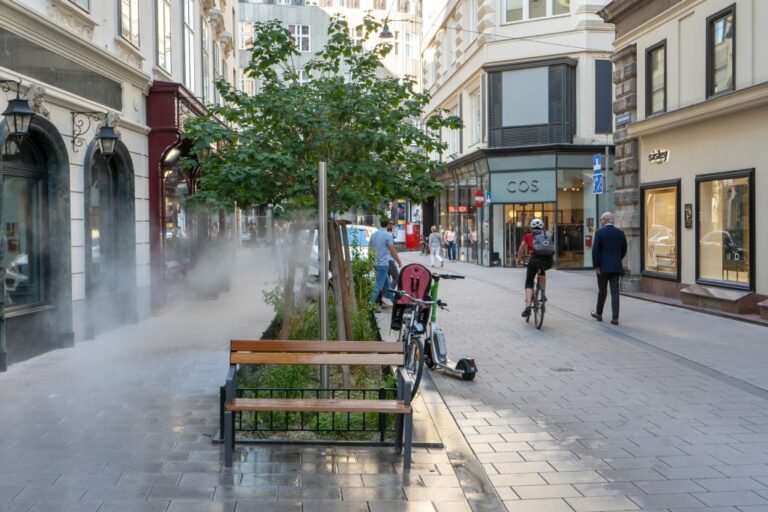 Sprühnebel-Stele in einer Baumscheibe, Bank, Fußgänger, Radfahrer