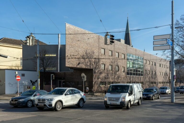 Trakt des Sophienspitals am Neubaugürtel mit Klinkerfassade und Kirchturmspitze im Hintergrund, vorne fahrende Autos