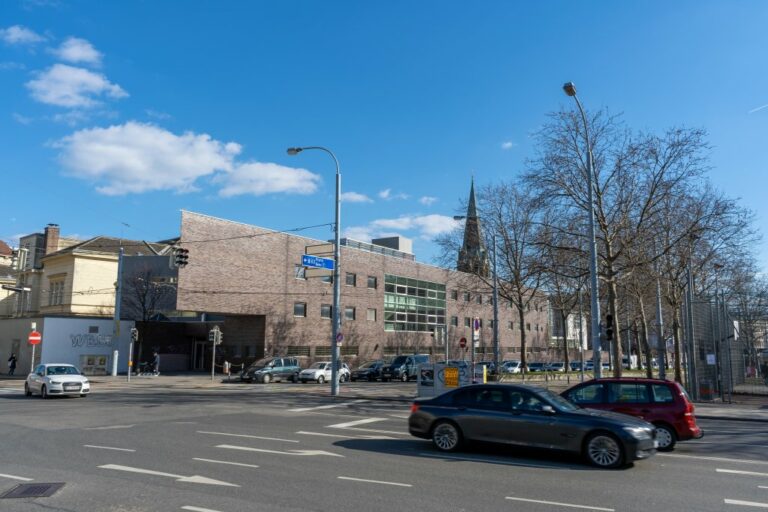 Trakt des Sophienspitals am Neubaugürtel mit Klinkerfassade und Kirchturmspitze im Hintergrund, vorne fahrende Autos