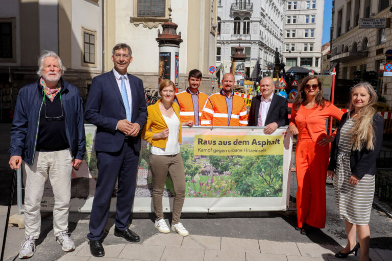 Personen stehen um ein Plakat am Petersplatz