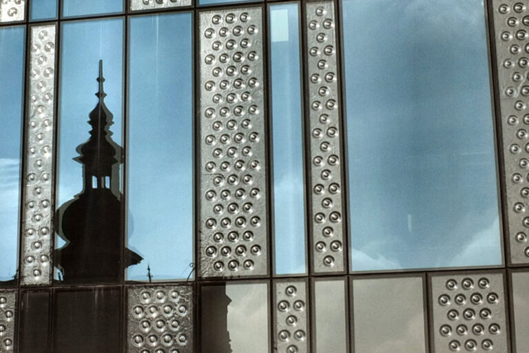 Fassadendetail eines Gebäudes in Delft mit Spiegelung eines Kirchturms